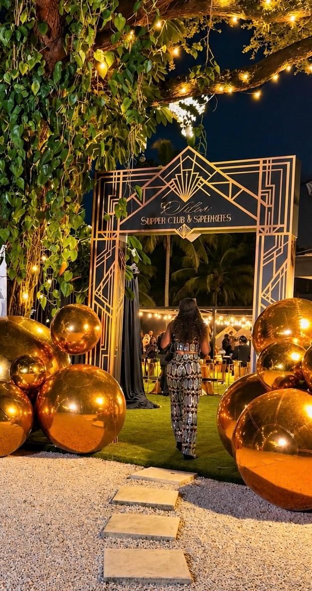 Guest entering an outdoor celebration through a gold geometric arch with gold balloons at CAL Events Cooper City