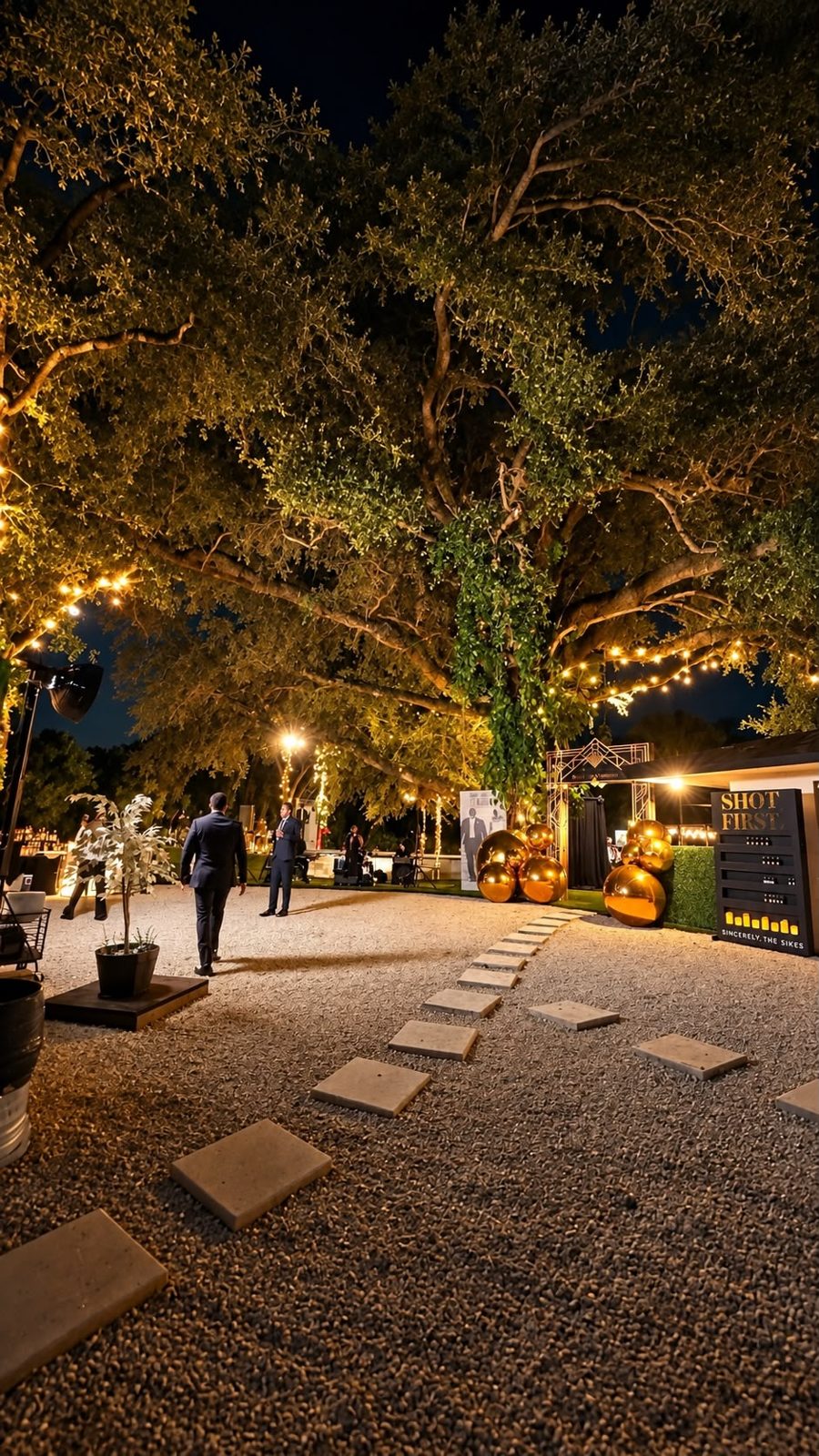 Guests walking along a garden path beneath trees and string lights at an evening event at CAL Events Cooper City